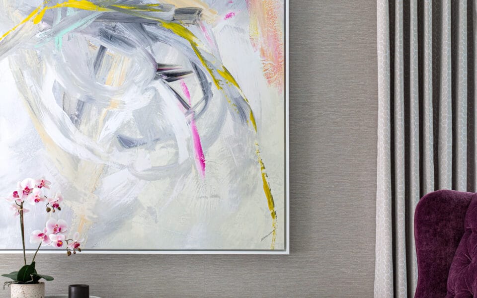 A purple wingback chair with a piece of modern art