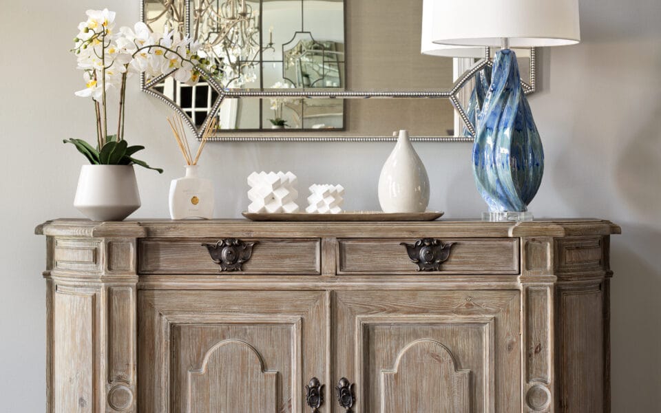 A hallway table with stunning blue lamp and mirror