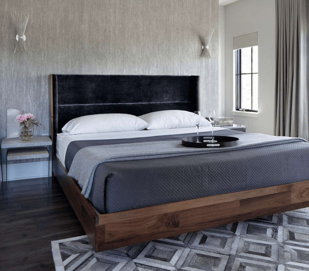 a bedroom with textured wallpaper and a modern platform bed with dark bedding